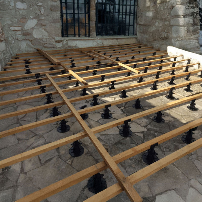 Préparation de la pose d'une terrasse d'une maison en pierre avec des plots et lambourdes en bois